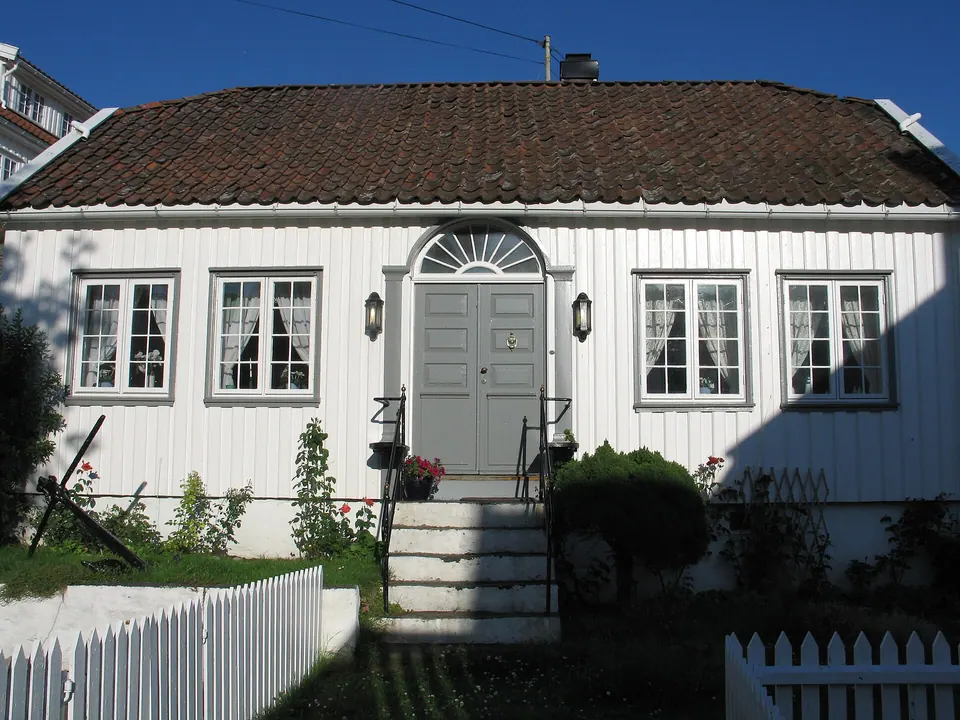 Weißes Holzhaus mit Lattenzaun in Brekkestø